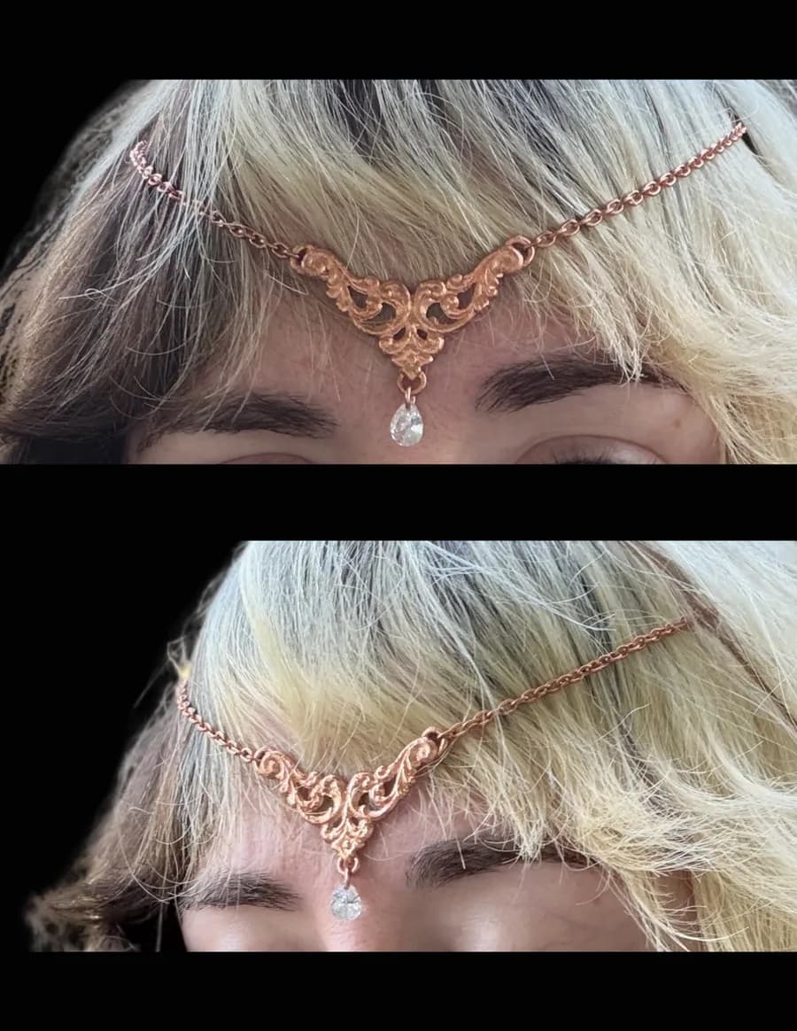 Woman with blonde hair wearing a delicate copper filigree hair crown with a teardrop crystal on her forehead